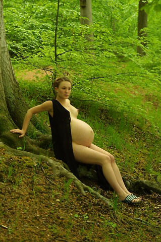 Pregnant woman nude along bank